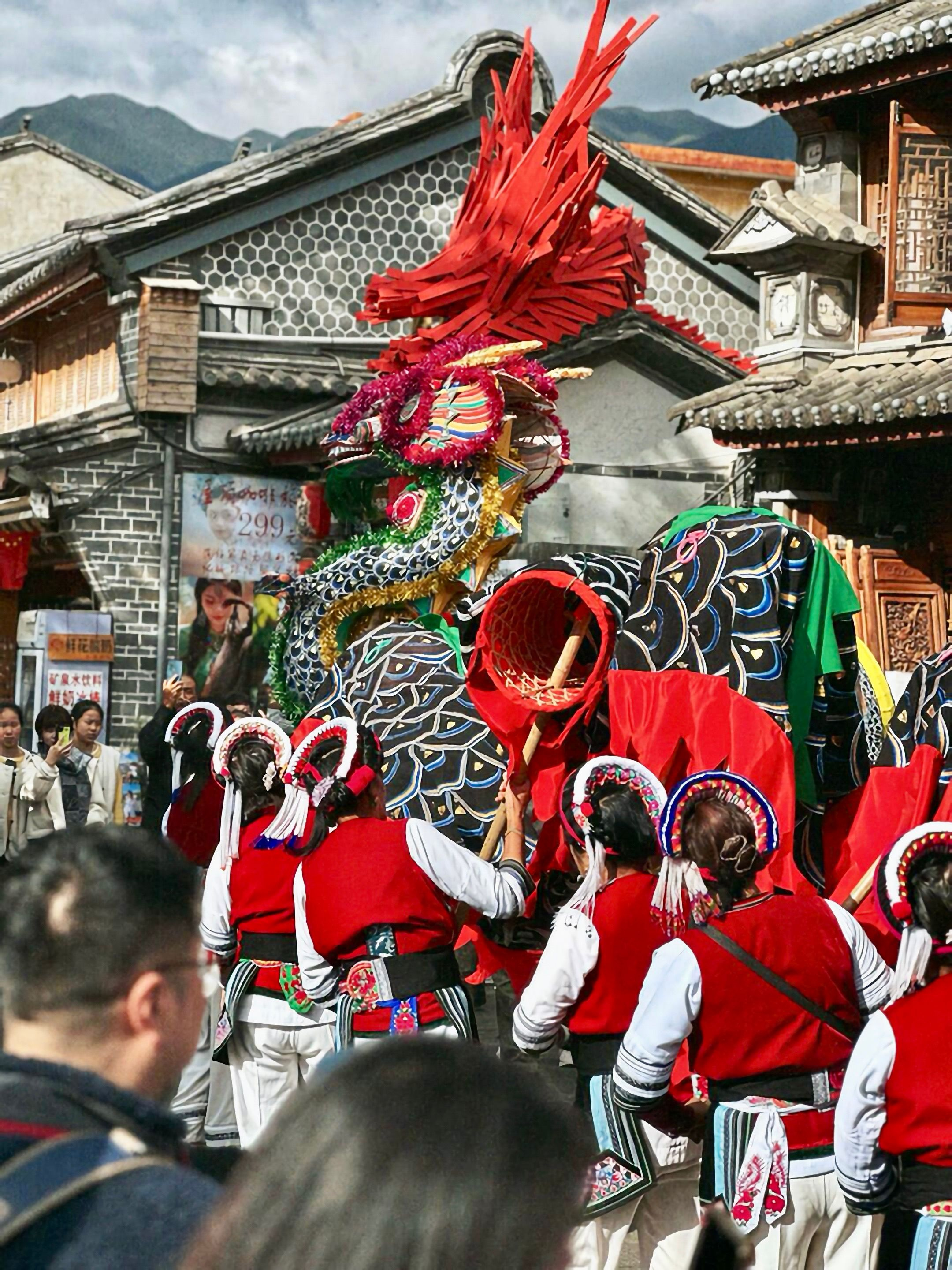 A dragon procession in an old Yunnan town with locals in red costumes